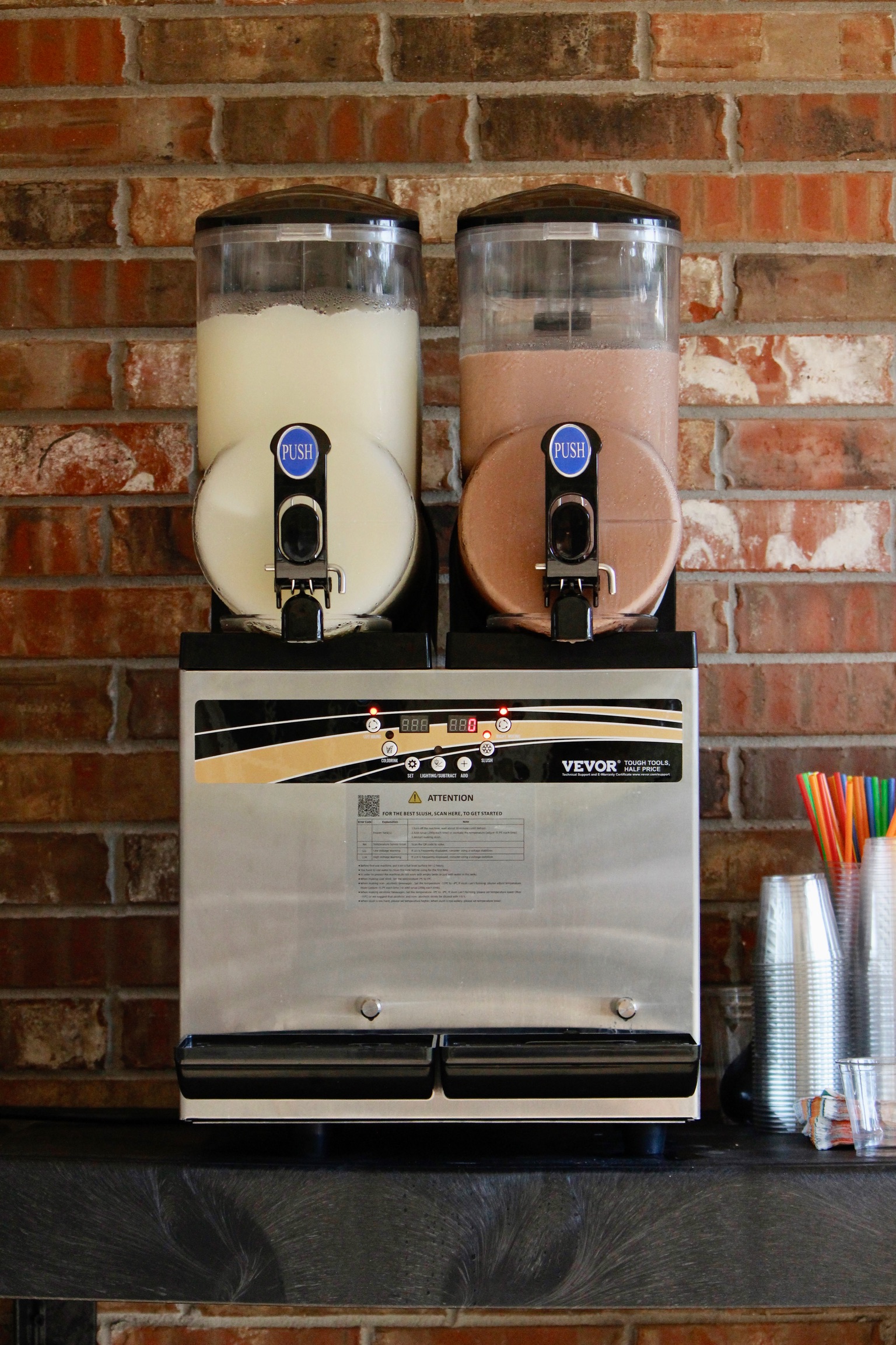 The Doc's Slushies dual-tank machine pouring a maroon slush