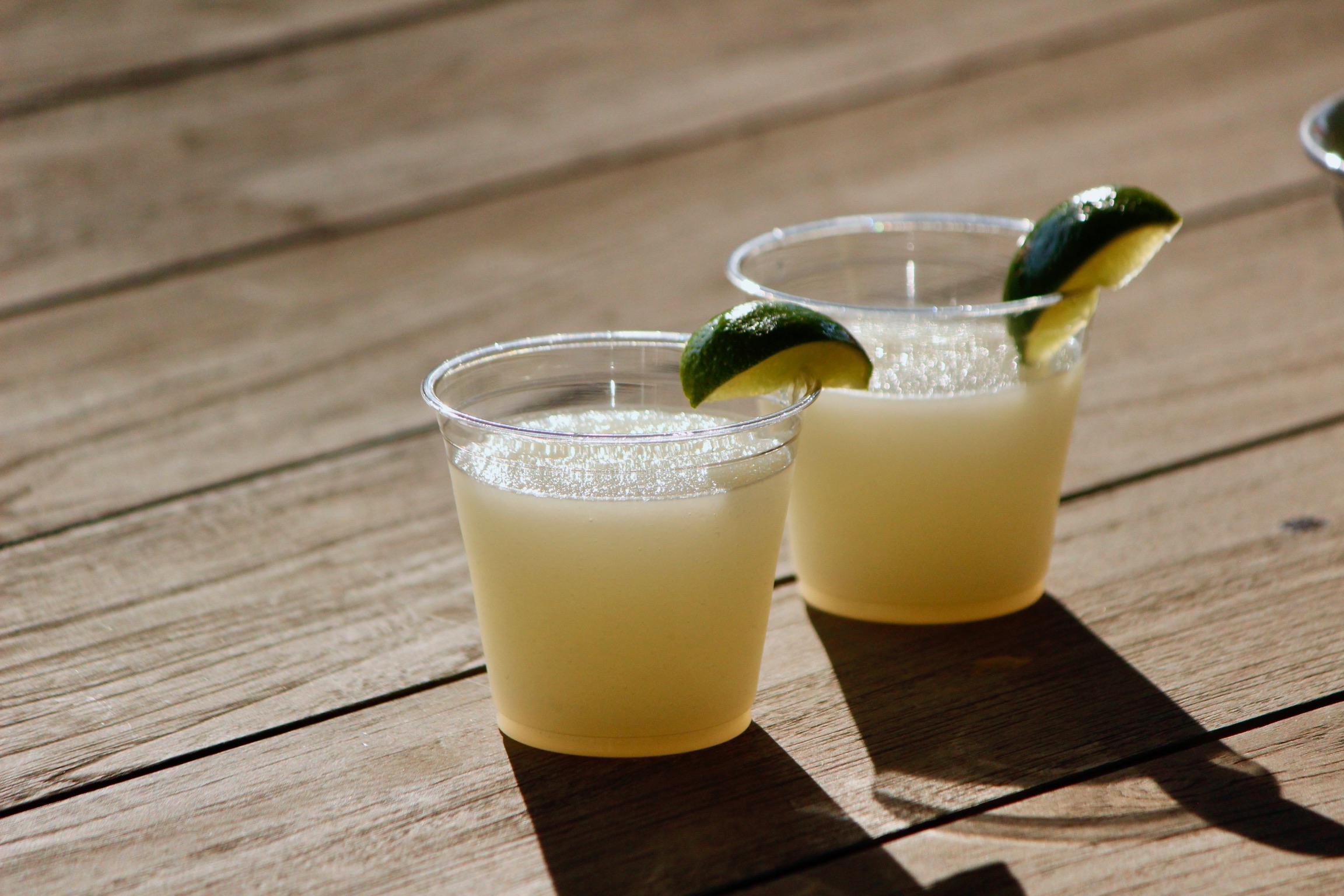 Two frozen lemonade slushies with lime, outdoors